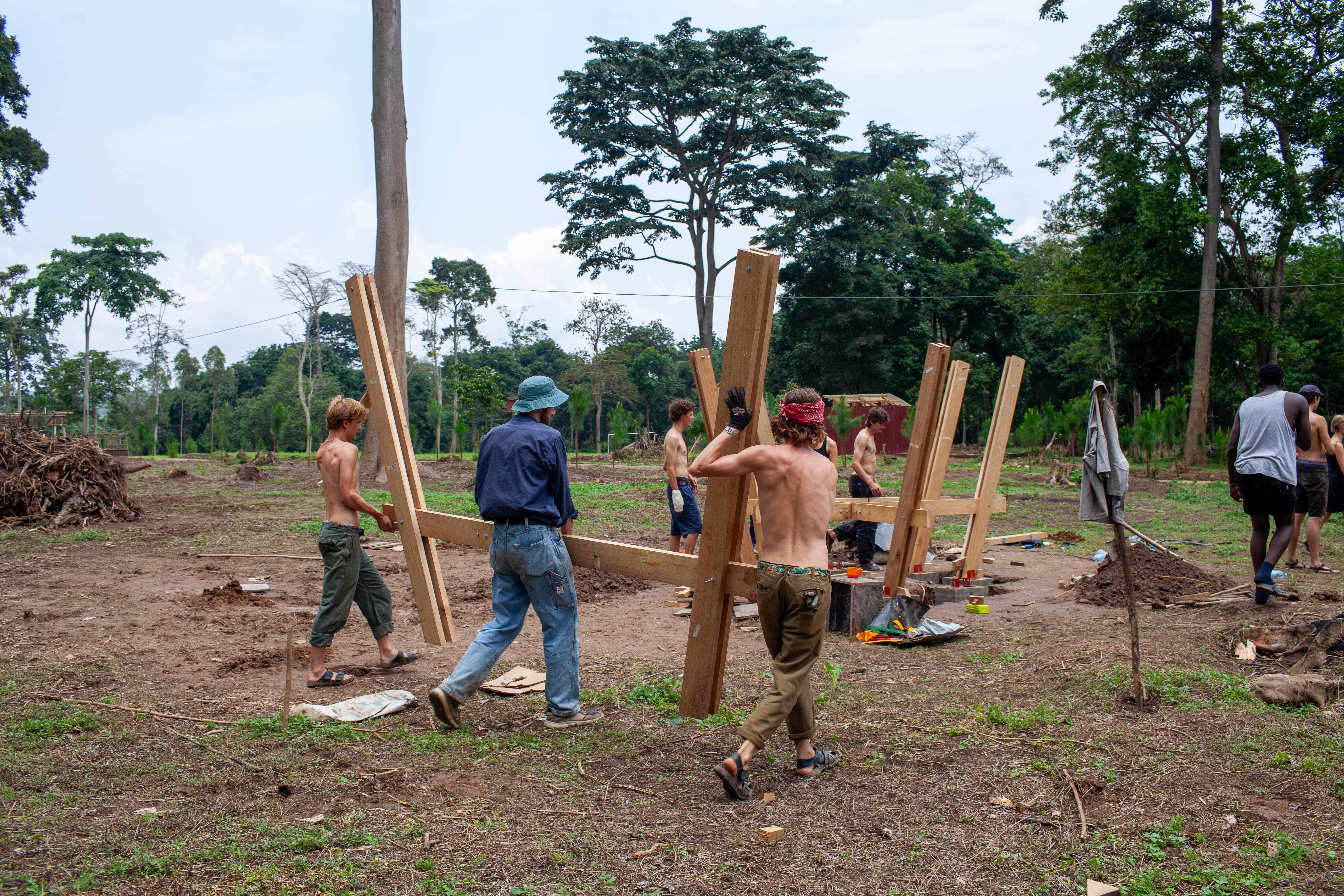 Teamwork in action as the main wooden frame of the pavilion is carried into place and assembled.