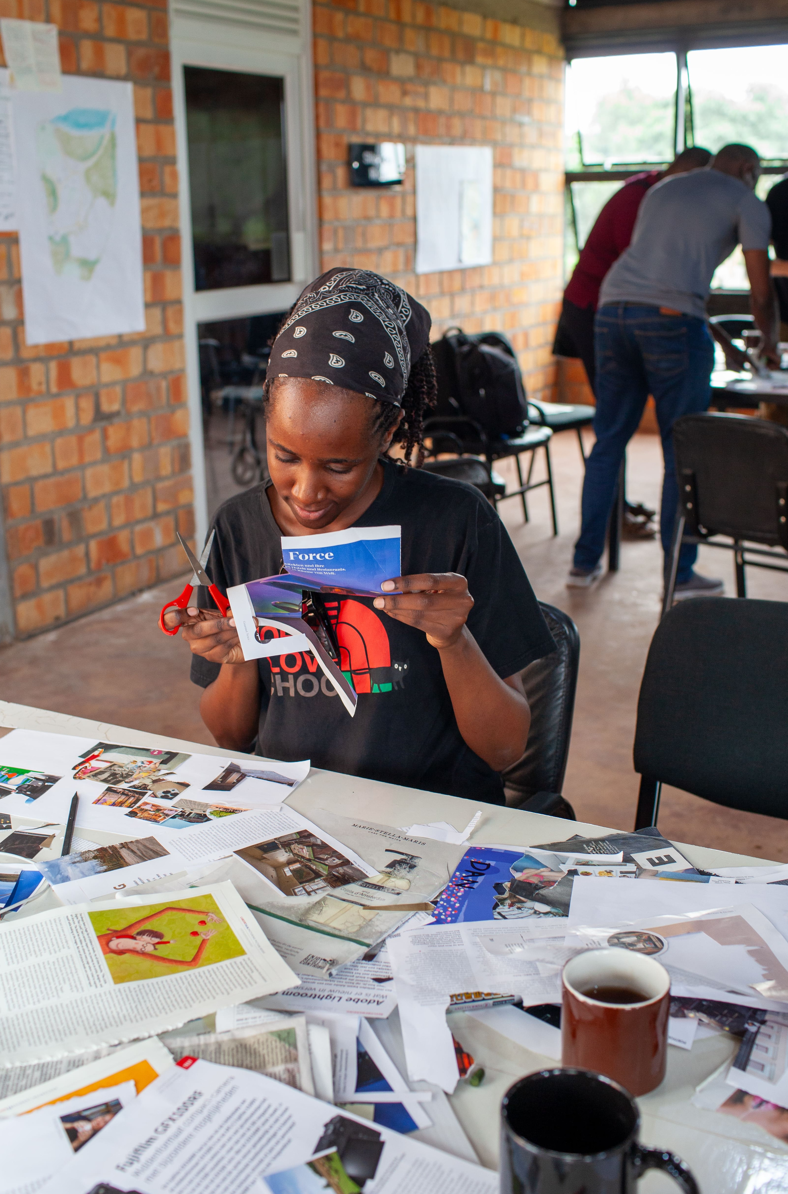 A student smiles as she carefully selects and cuts out images, adding her personal touch to the group's board.
