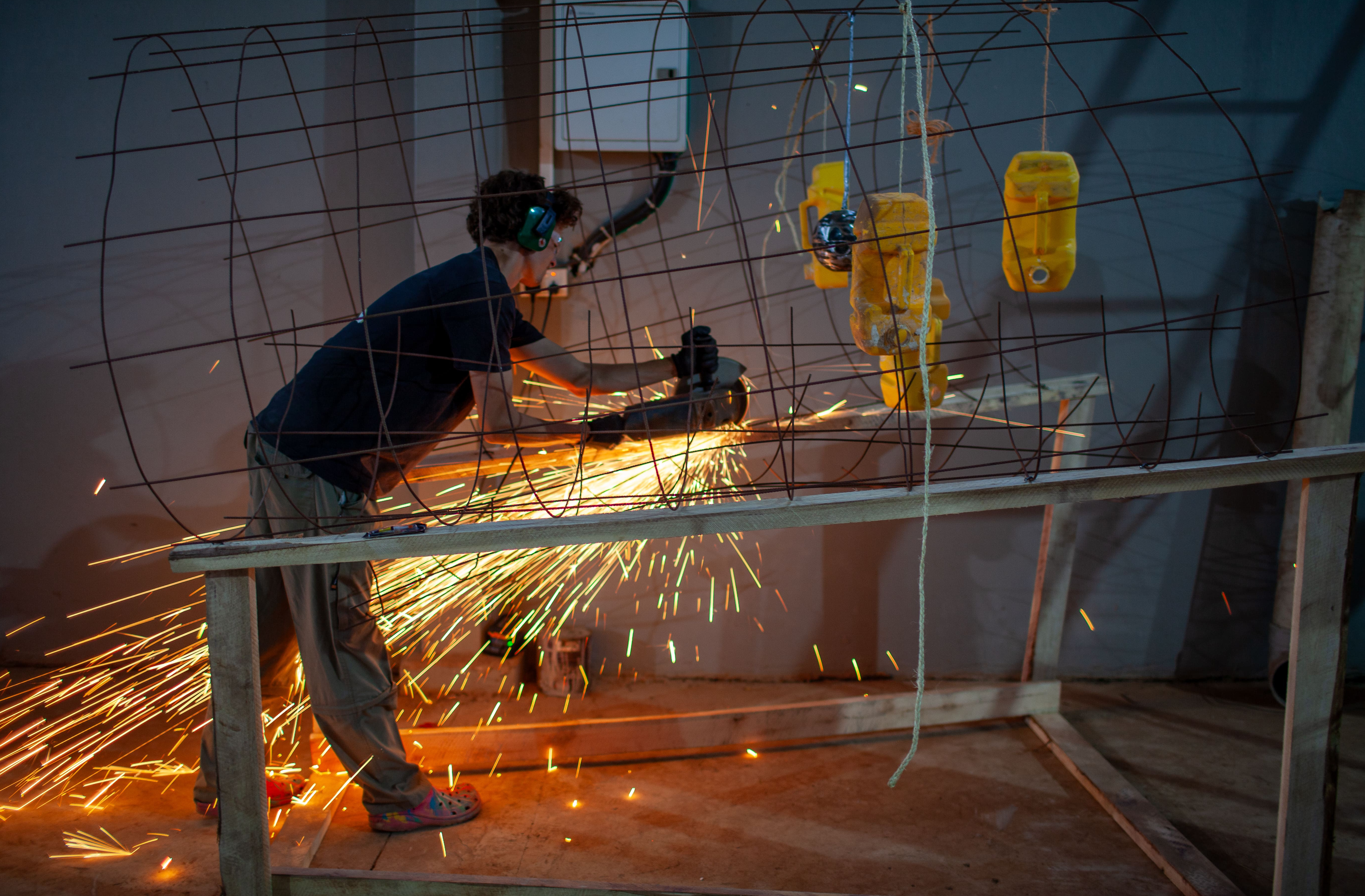 Sparks fly as a student works on fabricating the metal skeleton, bringing the design to life.