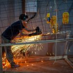 Sparks fly as a student works on fabricating the metal skeleton, bringing the design to life