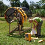 Students work on attaching recycled materials to the frame, adding color and texture to the final installation